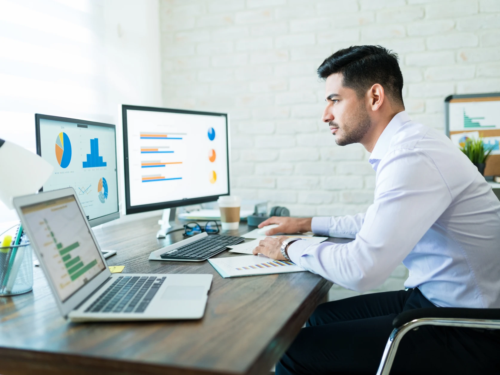 Merchant reviewing analytics dashboards on dual monitors